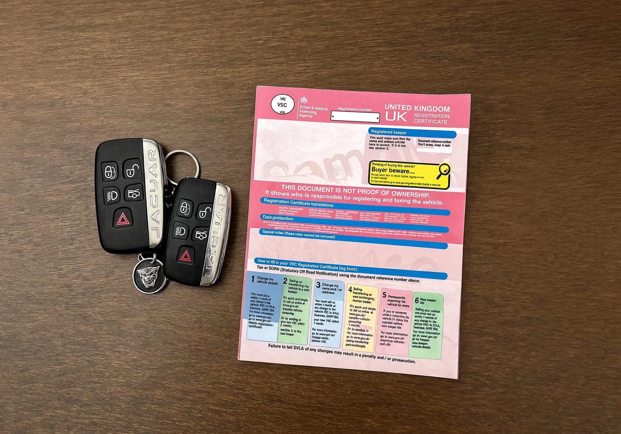 Supercar keys and V5 logbook on a wooden surface